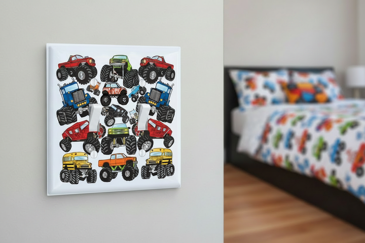 Monster truck double toggle light switch plate close-up in a boys bedroom — colorful monster truck illustrated switch cover with green, red, blue, orange and yellow trucks mounted on grey wall, boys room decor hardware
